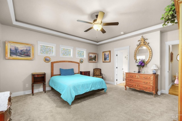 bedroom featuring light carpet, baseboards, and a tray ceiling