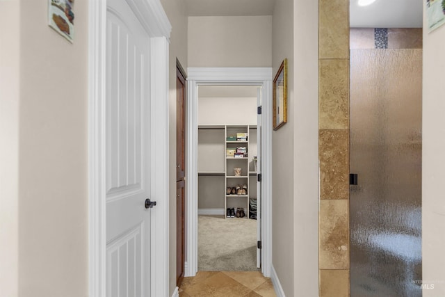 hallway with carpet and baseboards