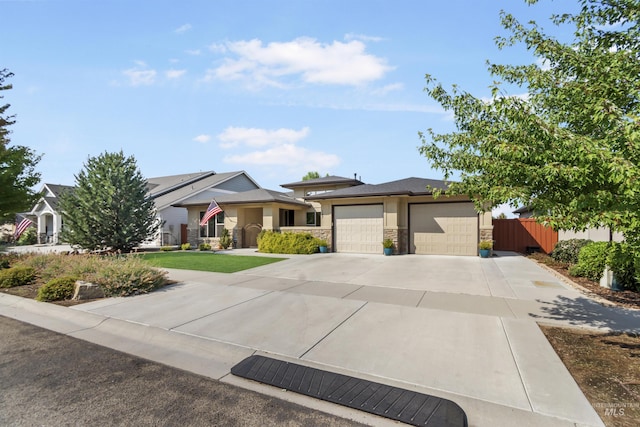 view of front of home featuring a garage, fence, concrete driveway, and stucco siding