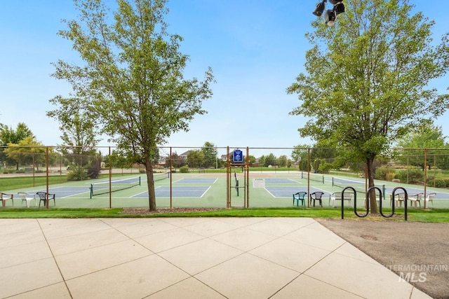 view of sport court with a tennis court and fence