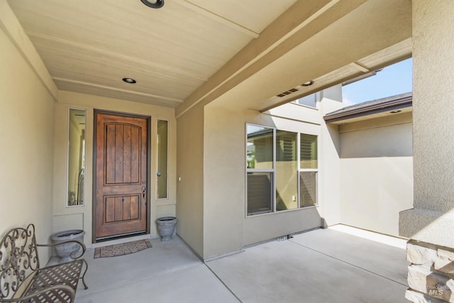 view of exterior entry with stucco siding