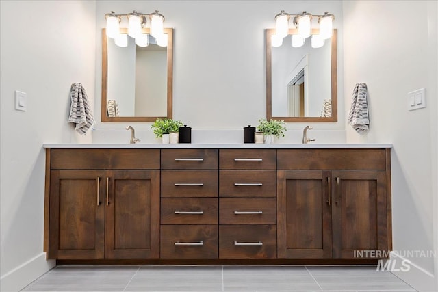 bathroom with double vanity, baseboards, and a sink