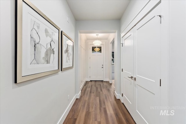 hallway with wood finished floors and baseboards