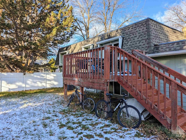 back of property featuring mansard roof, a shingled roof, fence, stairway, and a wooden deck