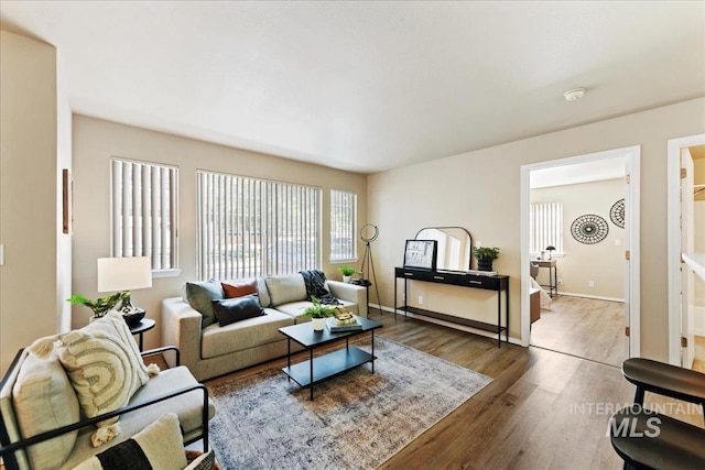 living area featuring baseboards and wood finished floors