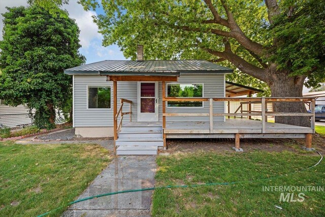 view of front of house featuring a wooden deck and a front yard