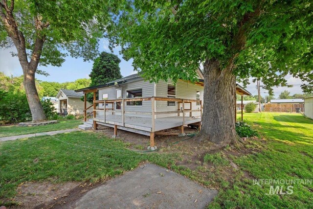 view of side of home featuring a yard and a deck