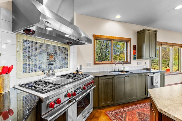 kitchen with a healthy amount of sunlight, sink, stainless steel appliances, and wall chimney range hood