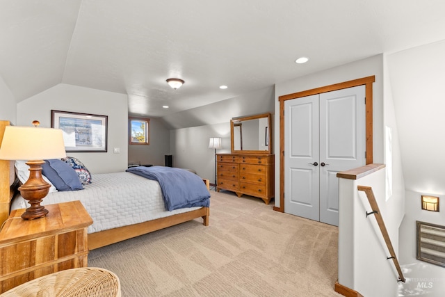 bedroom featuring vaulted ceiling, light carpet, and a closet