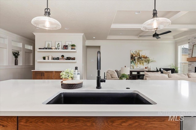 kitchen featuring a center island with sink, decorative light fixtures, ornamental molding, and sink