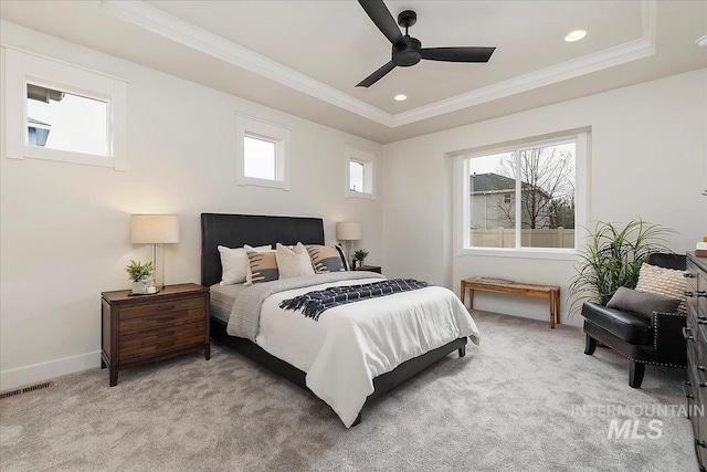 carpeted bedroom featuring ceiling fan, crown molding, and a tray ceiling