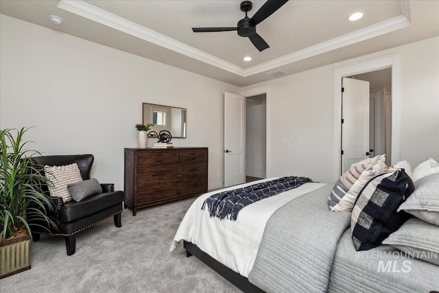 carpeted bedroom featuring ceiling fan, ornamental molding, and a tray ceiling