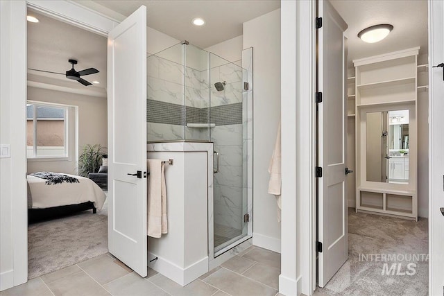 bathroom with ceiling fan, a shower with door, and tile patterned flooring