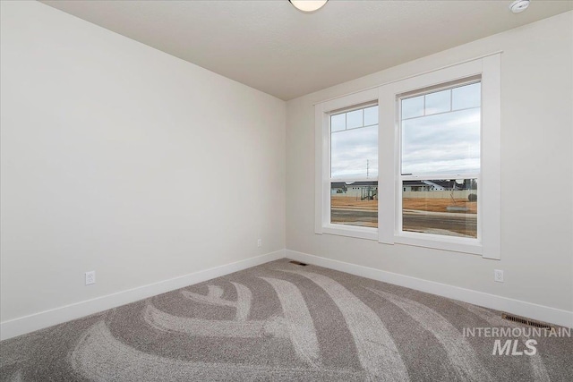 empty room with carpet flooring and lofted ceiling