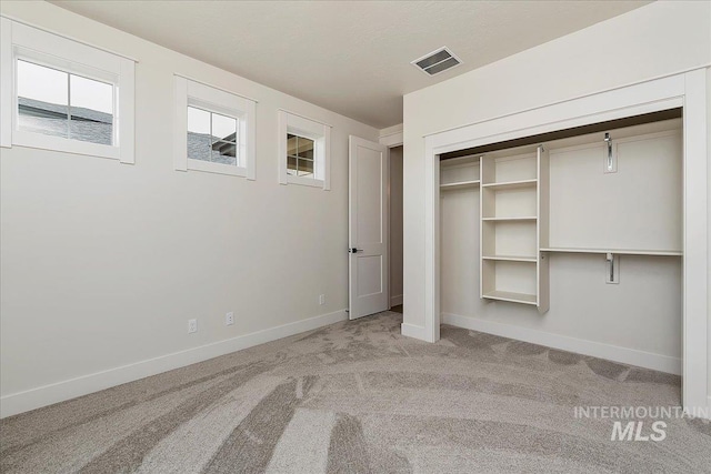 unfurnished bedroom with light carpet and a closet