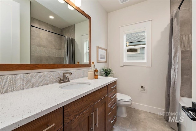 bathroom with walk in shower, tasteful backsplash, tile patterned flooring, toilet, and vanity