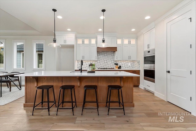 kitchen with white cabinetry, a kitchen island with sink, sink, and stainless steel appliances