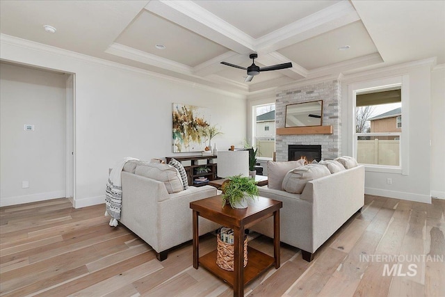 living room featuring a wealth of natural light, light wood-type flooring, ceiling fan, and coffered ceiling