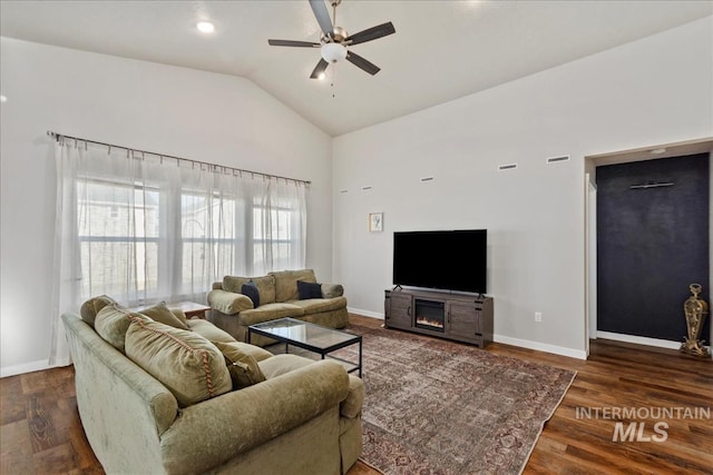 living room with dark wood-type flooring, ceiling fan, a fireplace, and vaulted ceiling