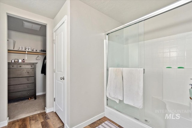 bathroom featuring wood-type flooring, a textured ceiling, and walk in shower