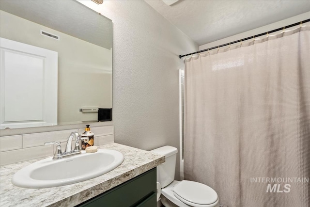 bathroom with curtained shower, backsplash, vanity, toilet, and a textured ceiling