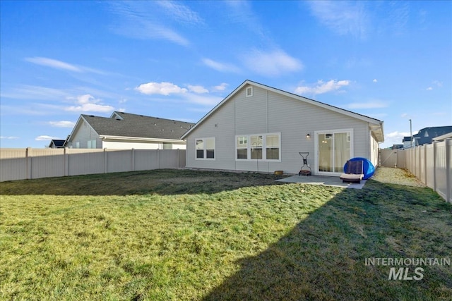 back of property with a yard and a patio area