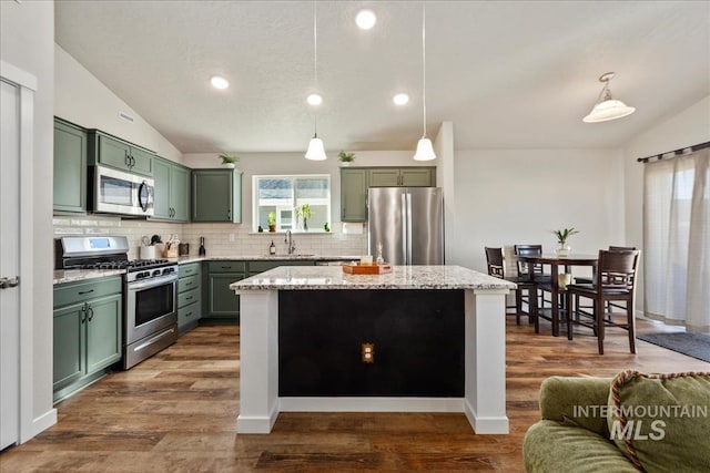 kitchen featuring lofted ceiling, sink, a center island, appliances with stainless steel finishes, and pendant lighting