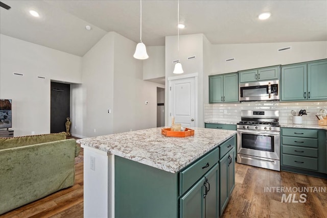 kitchen with pendant lighting, stainless steel appliances, high vaulted ceiling, and a kitchen island