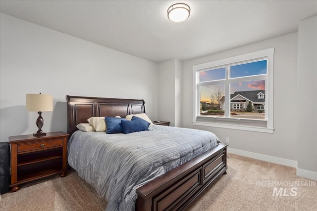 bedroom featuring baseboards and light carpet