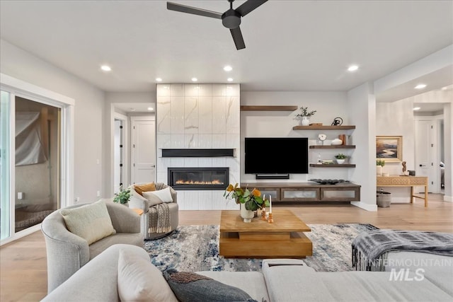 living room with recessed lighting, a tile fireplace, ceiling fan, and wood finished floors