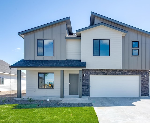 modern home with concrete driveway, covered porch, an attached garage, board and batten siding, and stone siding