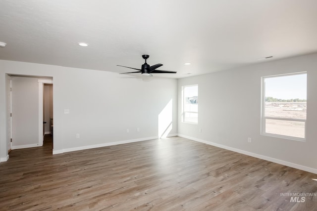 unfurnished room with recessed lighting, light wood-type flooring, a ceiling fan, and baseboards