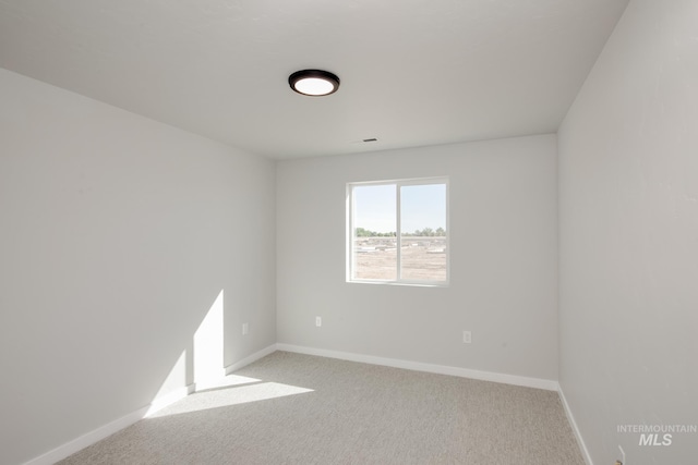 empty room with light carpet and baseboards