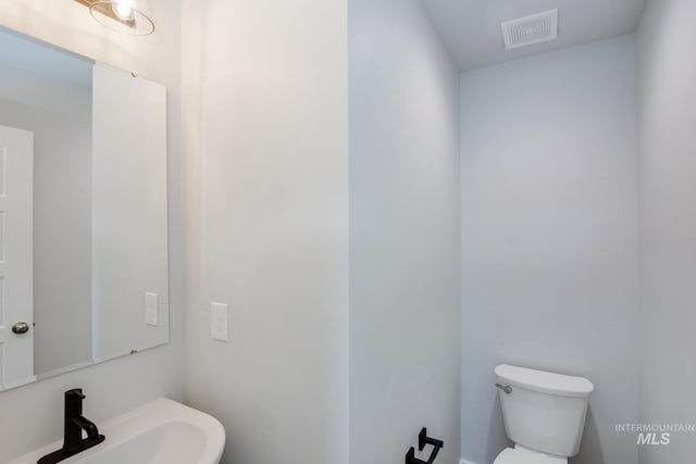 bathroom featuring visible vents, a sink, and toilet