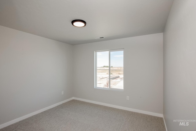 empty room featuring baseboards and carpet flooring