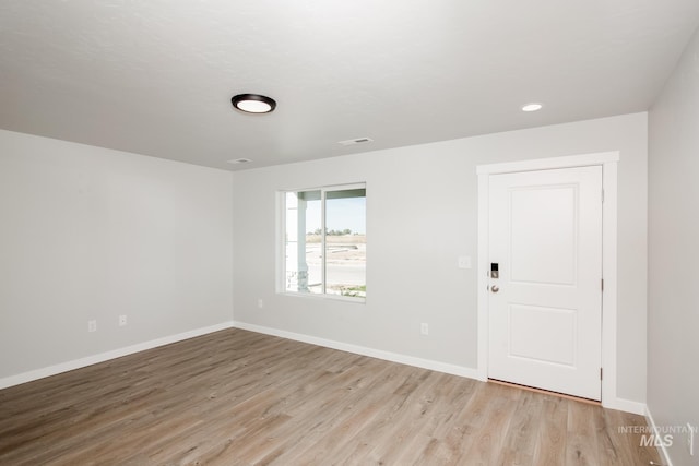 empty room with light wood-type flooring and baseboards