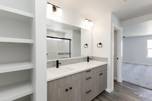2735 N Silver Wolf Ave, Star, ID 83669 - bathroom with double vanity, baseboards, a sink, and wood finished floors