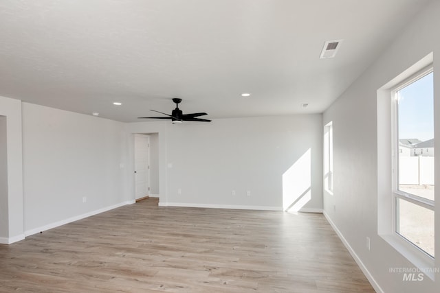 empty room with light wood-style flooring, visible vents, baseboards, and recessed lighting