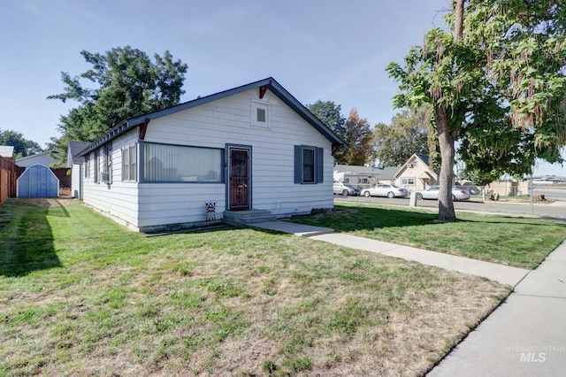 view of front facade with a storage shed and a front yard