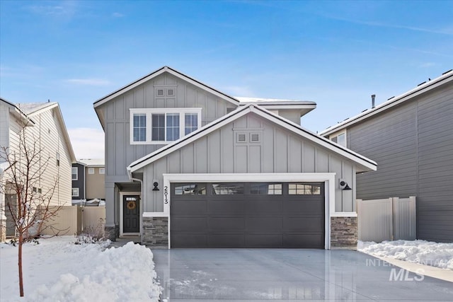 view of front of property with an attached garage, fence, board and batten siding, and concrete driveway