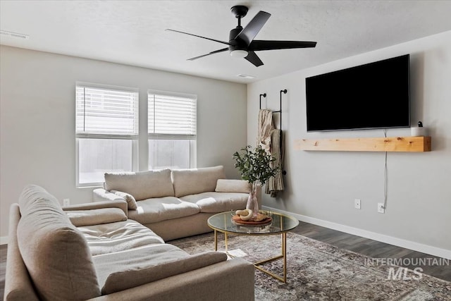 living area featuring a ceiling fan, baseboards, visible vents, and wood finished floors