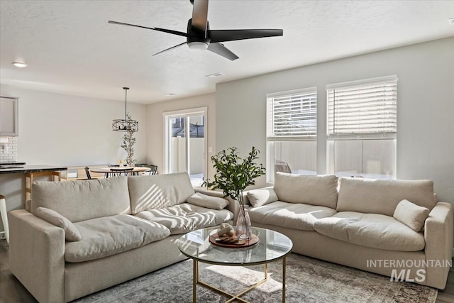 living room with ceiling fan and a textured ceiling