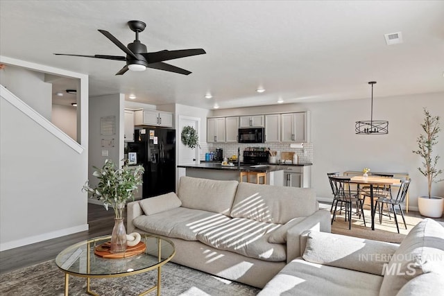 living area featuring baseboards, visible vents, a ceiling fan, wood finished floors, and recessed lighting