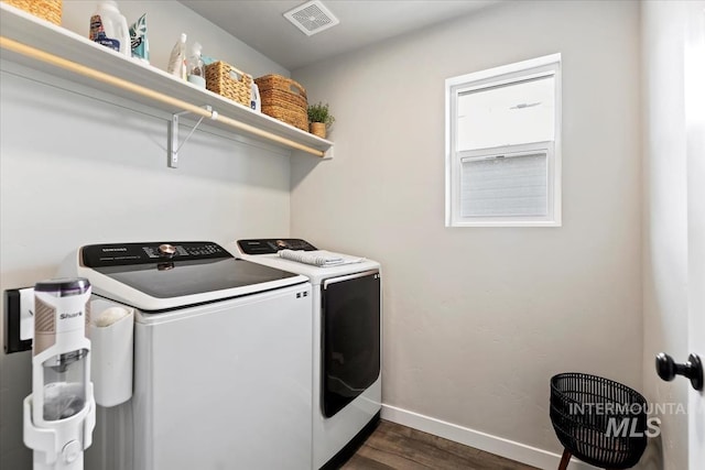 clothes washing area featuring laundry area, baseboards, visible vents, washer and clothes dryer, and dark wood-style flooring