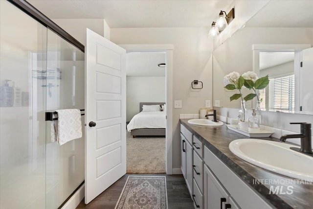 ensuite bathroom with a sink, a shower stall, ensuite bath, and double vanity