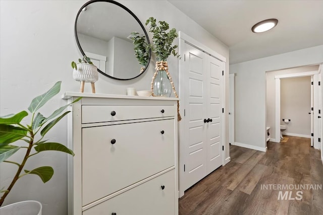 hallway with wood finished floors and baseboards