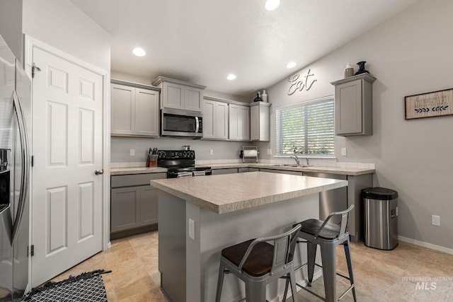 13221 S Clarion River Ave, Nampa, ID 83686 - kitchen with stainless steel appliances, gray cabinetry, a kitchen breakfast bar, a sink, and light countertops