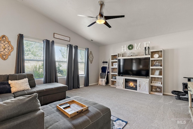 13221 S Clarion River Ave, Nampa, ID 83686 - living room with ceiling fan, vaulted ceiling, carpet flooring, a glass covered fireplace, and baseboards