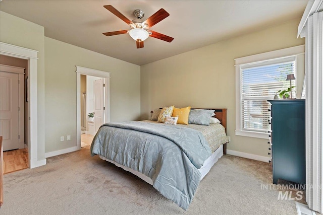 carpeted bedroom featuring baseboards, ceiling fan, and connected bathroom