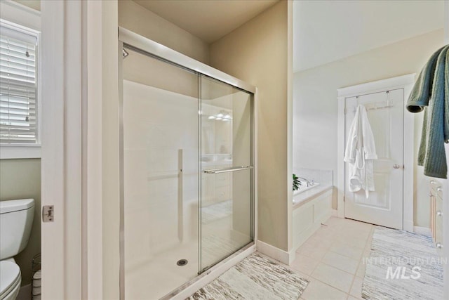 bathroom with tile patterned floors, a stall shower, toilet, and a bath